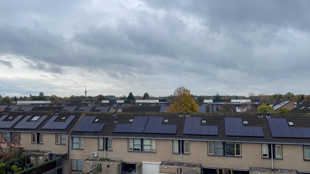 "Rij van woningen in Roosendaal voorzien van zonnepanelen, geïnstalleerd door Led Up voor energie-efficiëntie bij woningcorporaties."